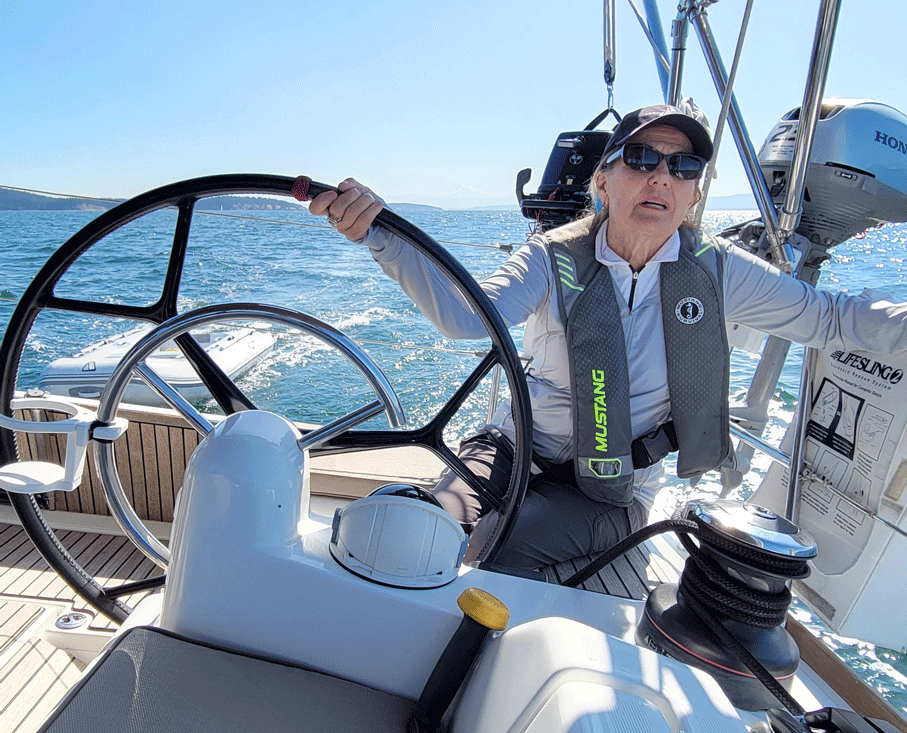 woman at helm of sailboat